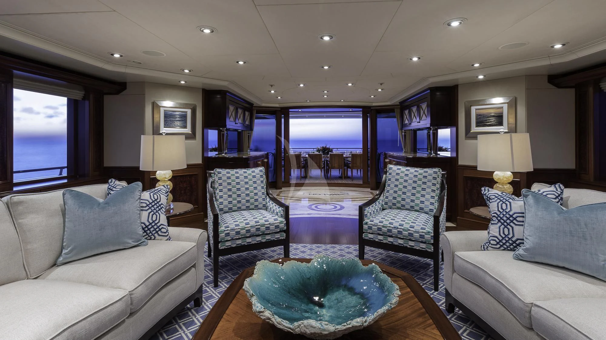 a living room with a large blue table and a large window aboard AVALON Yacht for Sale