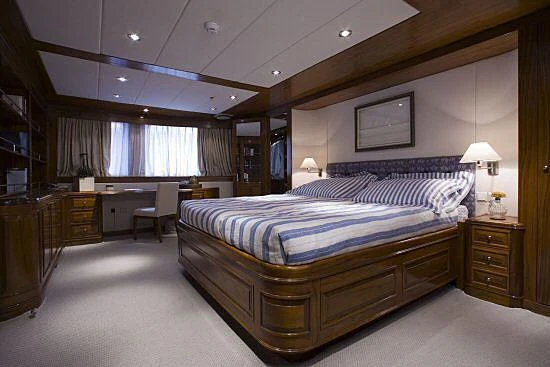 a bedroom with a bed and a desk aboard MASQUENADA Yacht for Sale