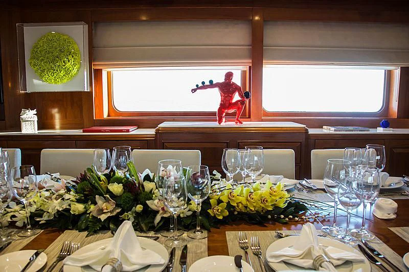 a table with a plate of food and glasses on it aboard MASQUENADA Yacht for Sale