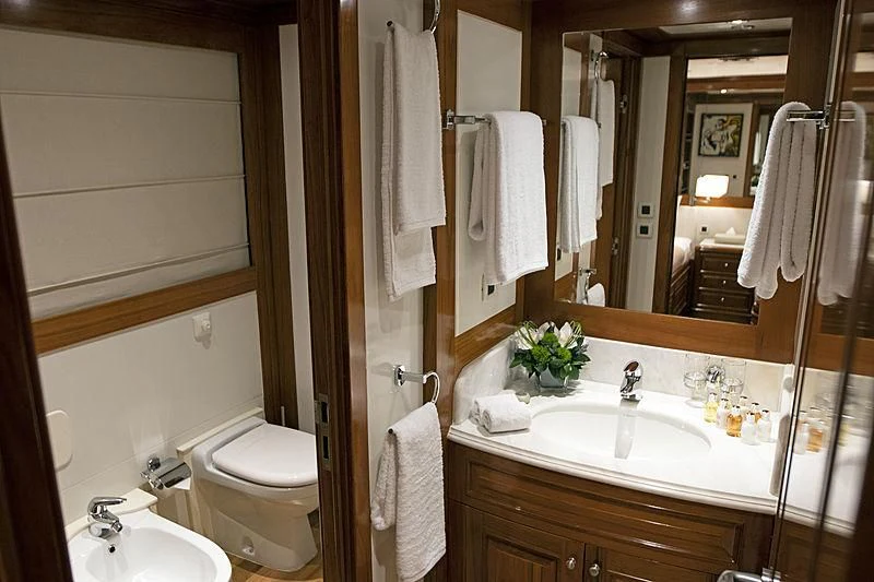 a bathroom with a sink toilet and towels aboard MASQUENADA Yacht for Sale