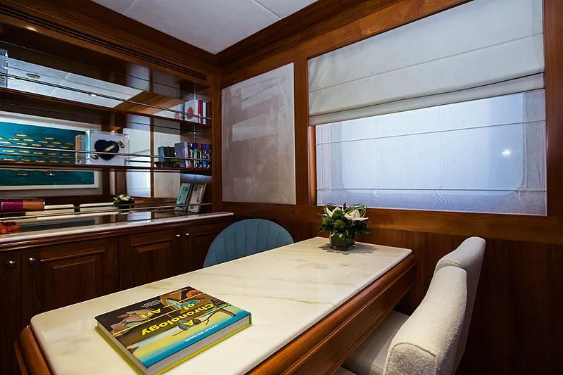 a room with a desk and a book on the table aboard MASQUENADA Yacht for Sale