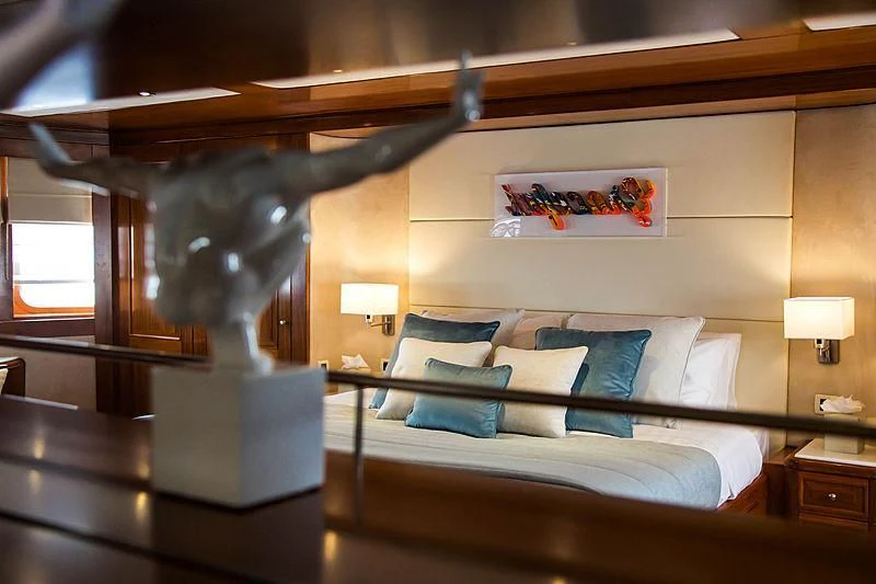 a bed with a large headboard aboard MASQUENADA Yacht for Sale