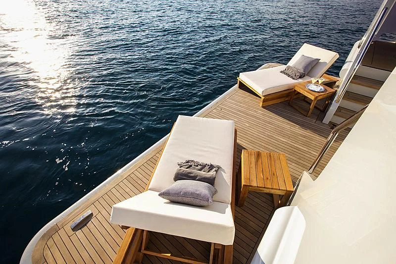 a deck with a view of the water and a boat aboard MASQUENADA Yacht for Sale