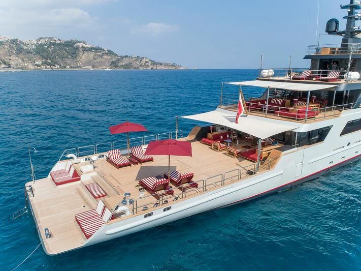 a boat with chairs and umbrellas on the deck aboard MASQUENADA Yacht for Sale