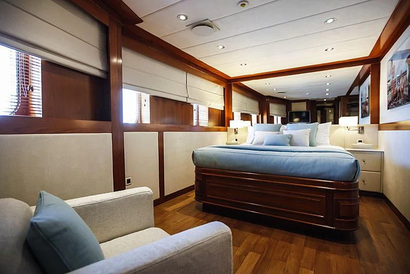 a bedroom with a bed and a couch aboard MASQUENADA Yacht for Sale