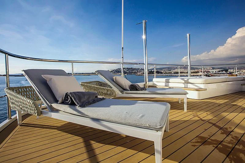 a deck with a bed and a large body of water in the background aboard MASQUENADA Yacht for Sale