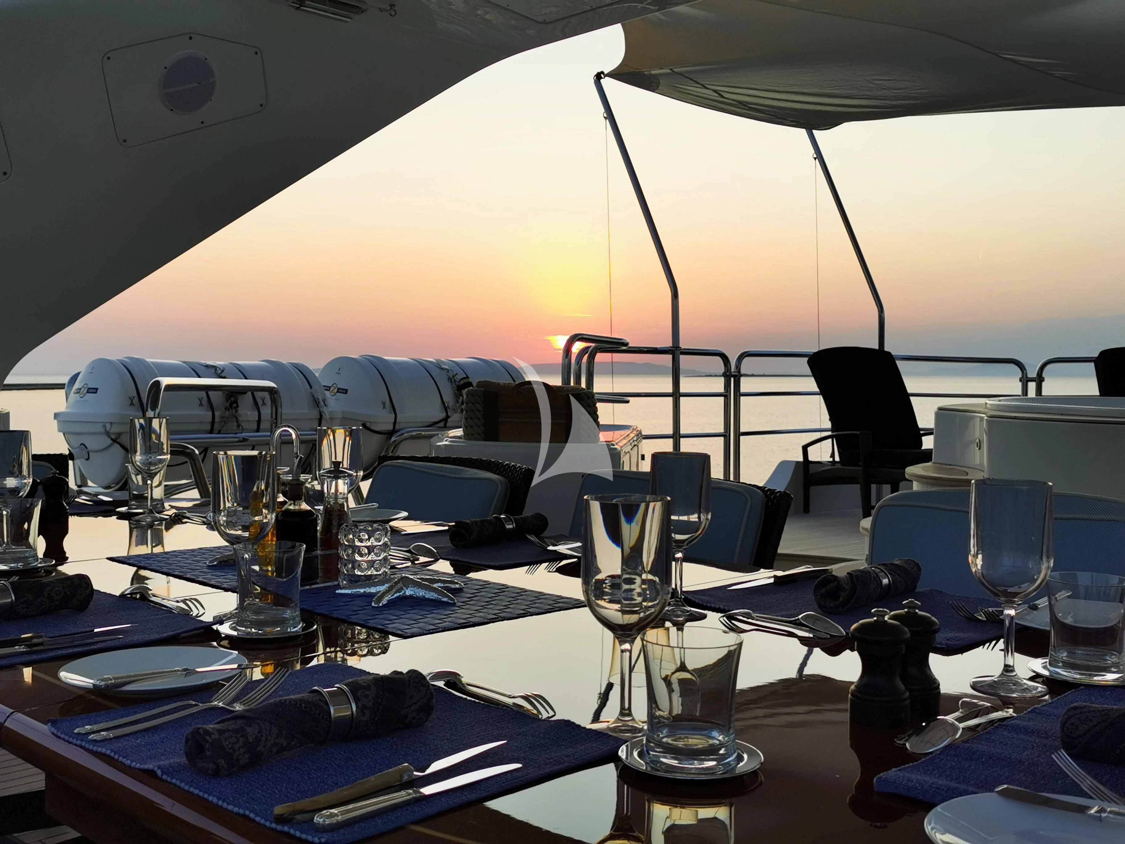 a table with glasses and a laptop aboard EVERBLUE Yacht for Sale