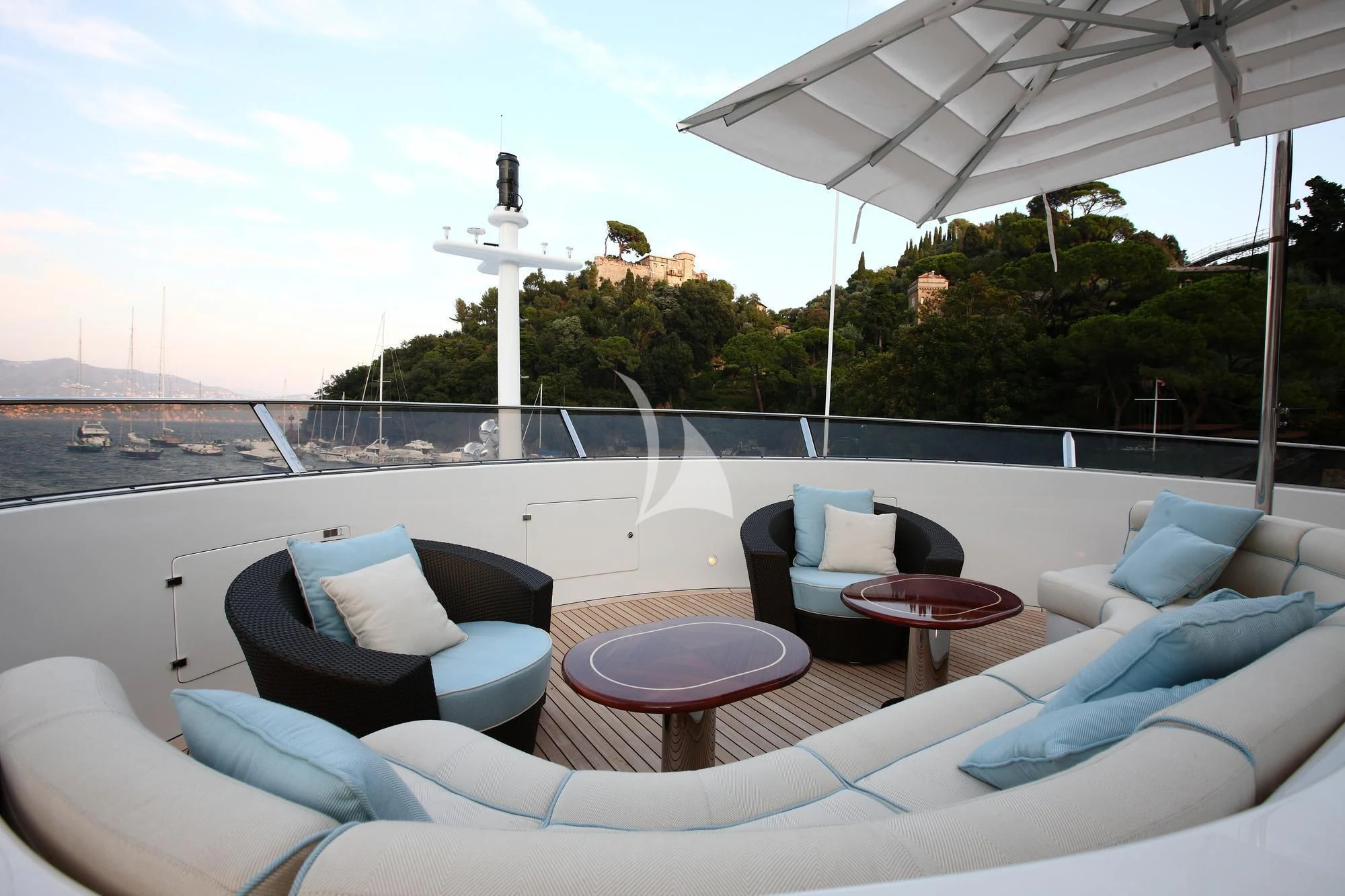 a large white lounge chair on a balcony overlooking a body of water aboard EVERBLUE Yacht for Sale