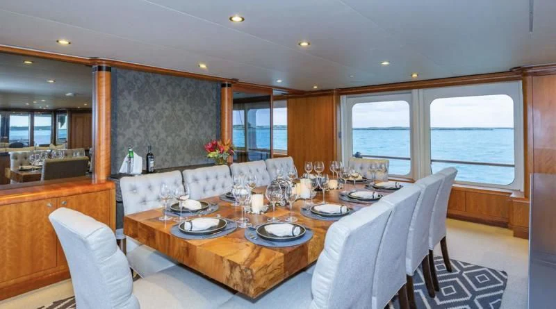 a large dining table with plates and chairs aboard SEA CLASS Yacht for Sale