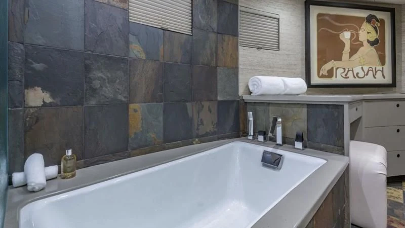 a bathroom with a bathtub and a painting on the wall aboard SEA CLASS Yacht for Sale