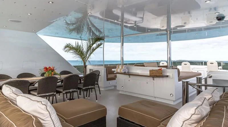 a room with a large white bed and a table with chairs aboard SEA CLASS Yacht for Sale