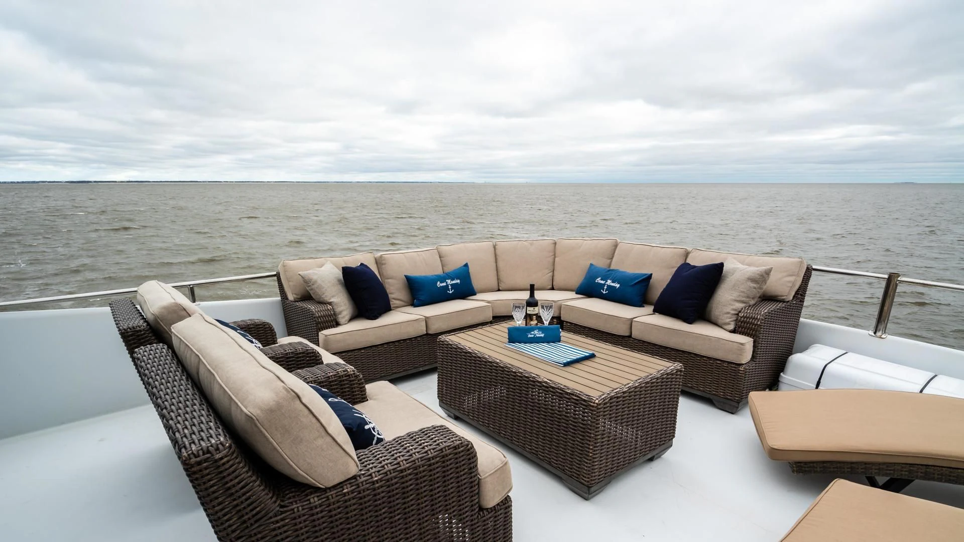 a couch and a table on a balcony overlooking a body of water aboard BUSINESS TRIP 2 Yacht for Sale