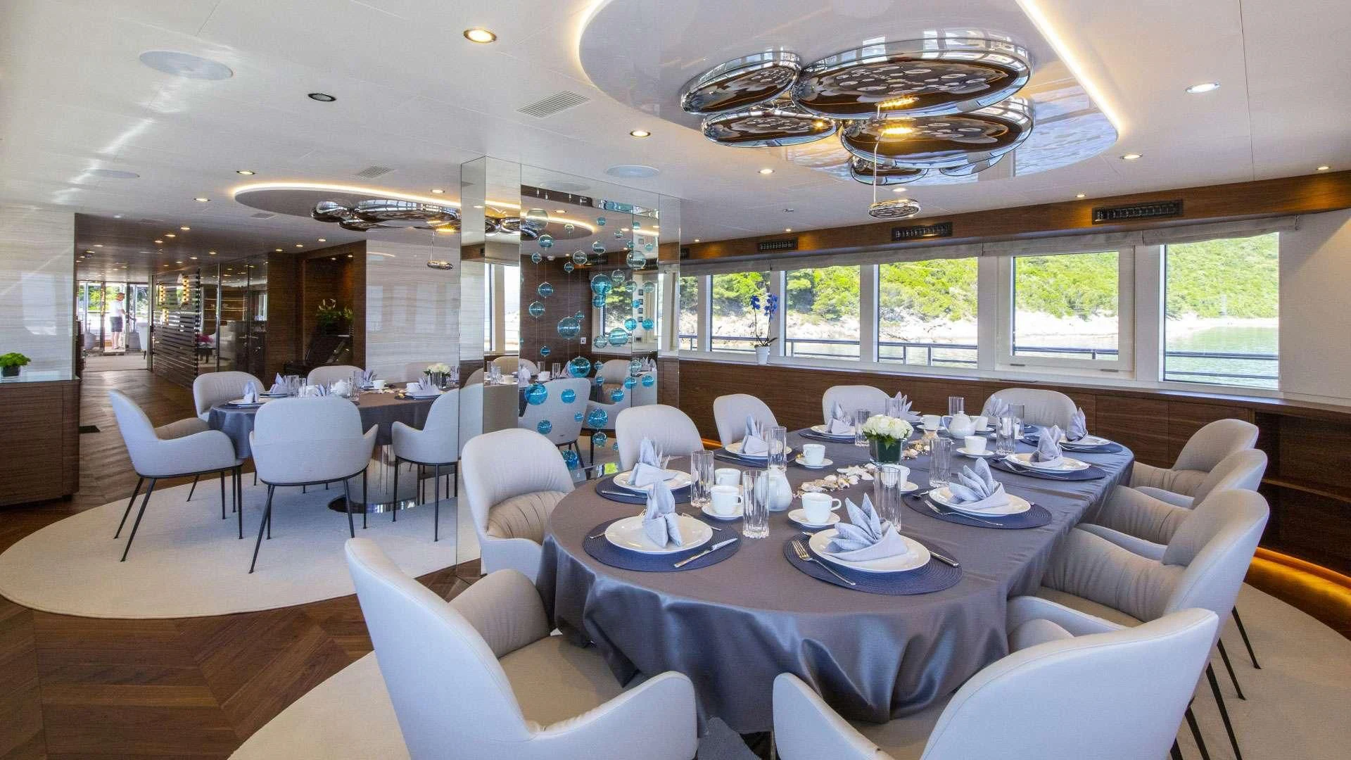 a large room with tables and chairs aboard M/Y ANTHEA Yacht for Sale