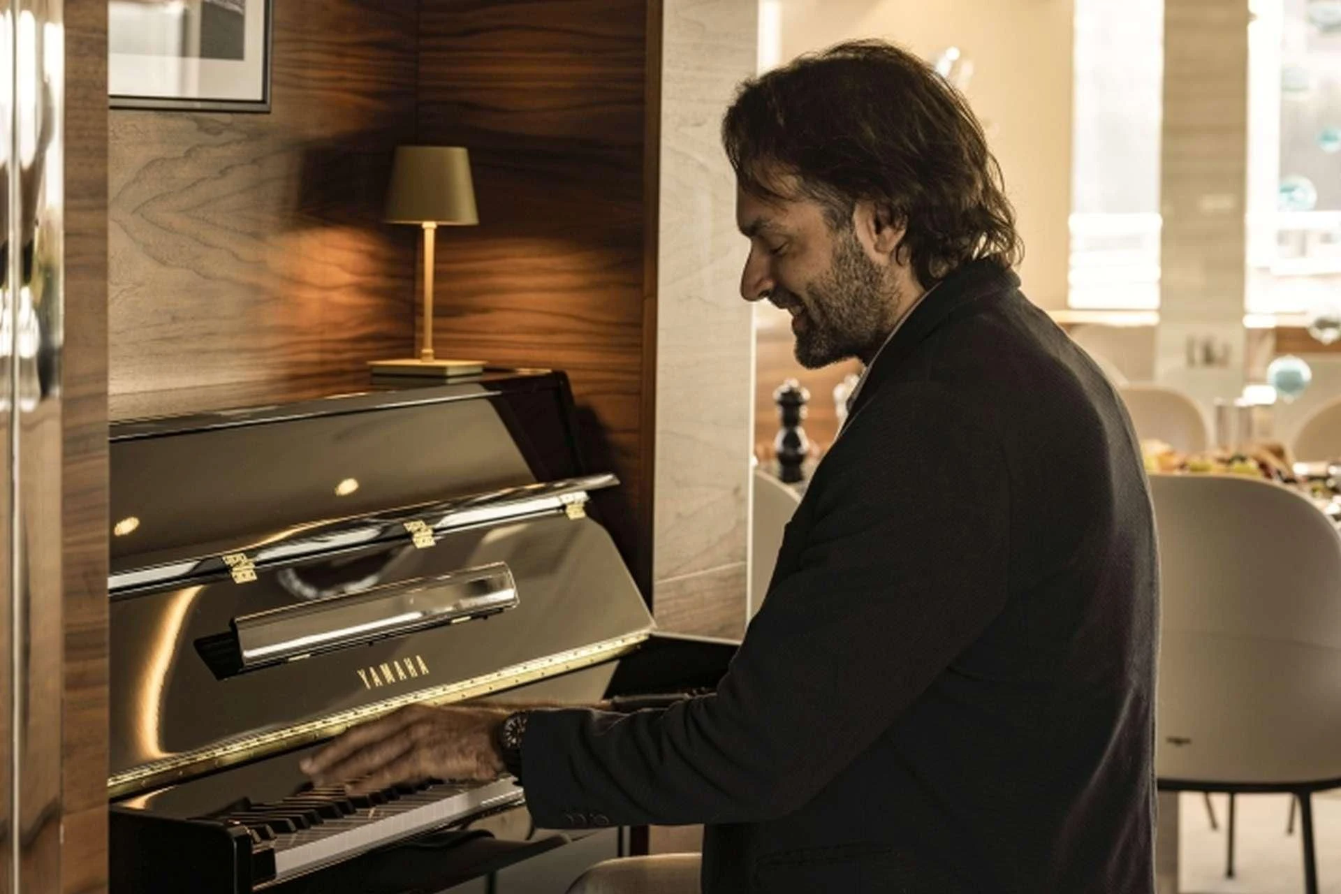 a man playing a piano aboard M/Y ANTHEA Yacht for Sale