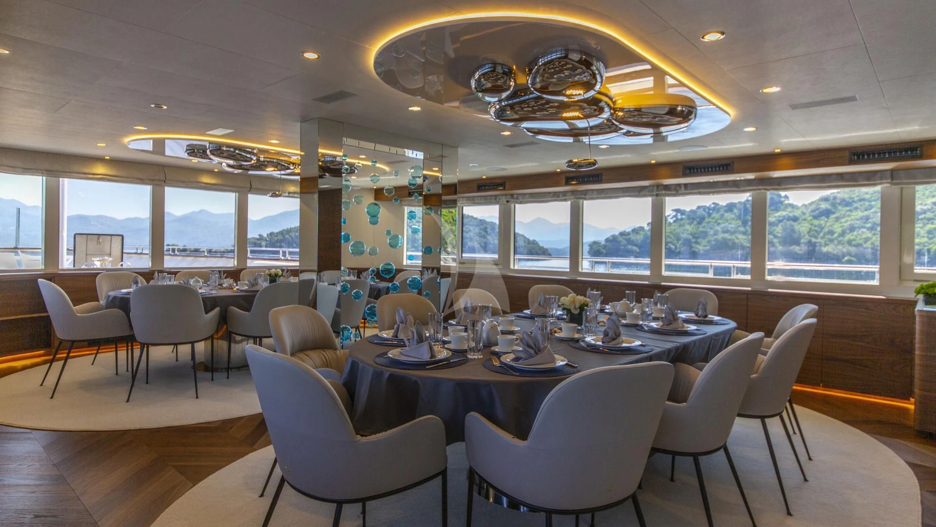 a room with tables and chairs aboard M/Y ANTHEA Yacht for Sale