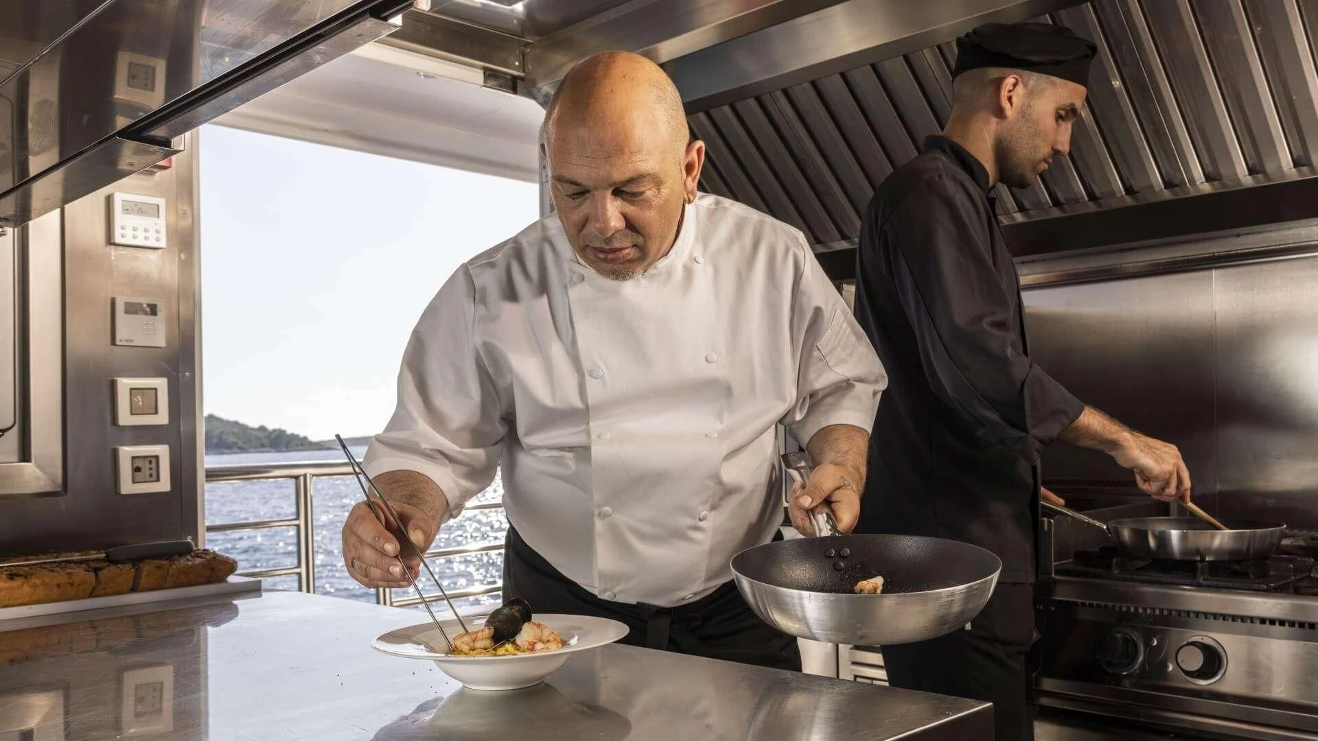 a couple of men cooking in a kitchen aboard M/Y ANTHEA Yacht for Sale