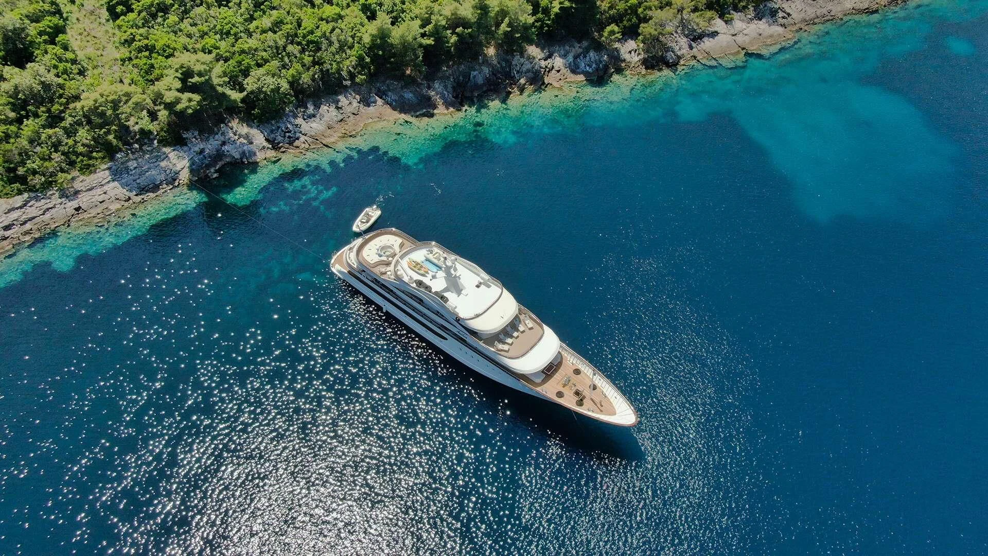 a white sports car on a blue body of water aboard M/Y ANTHEA Yacht for Sale
