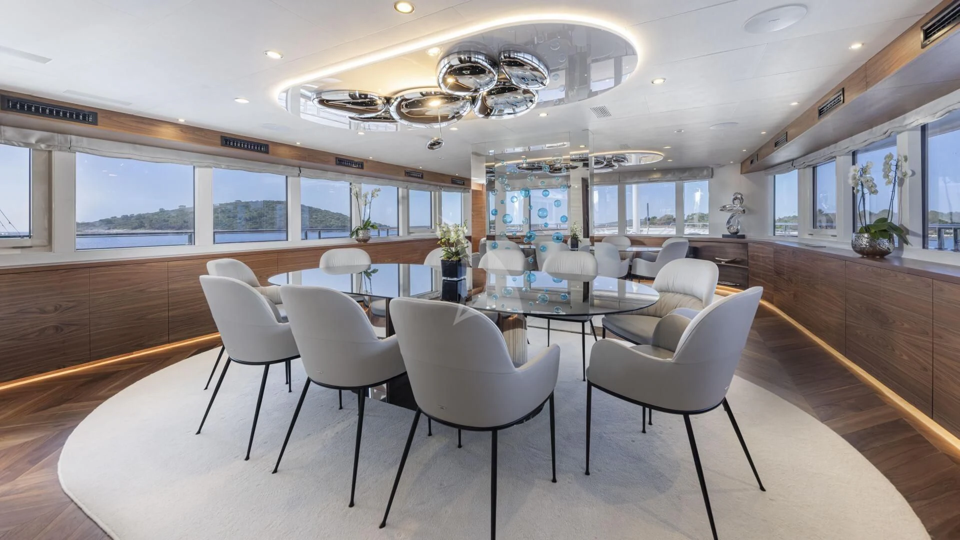 a room with tables and chairs aboard M/Y ANTHEA Yacht for Sale
