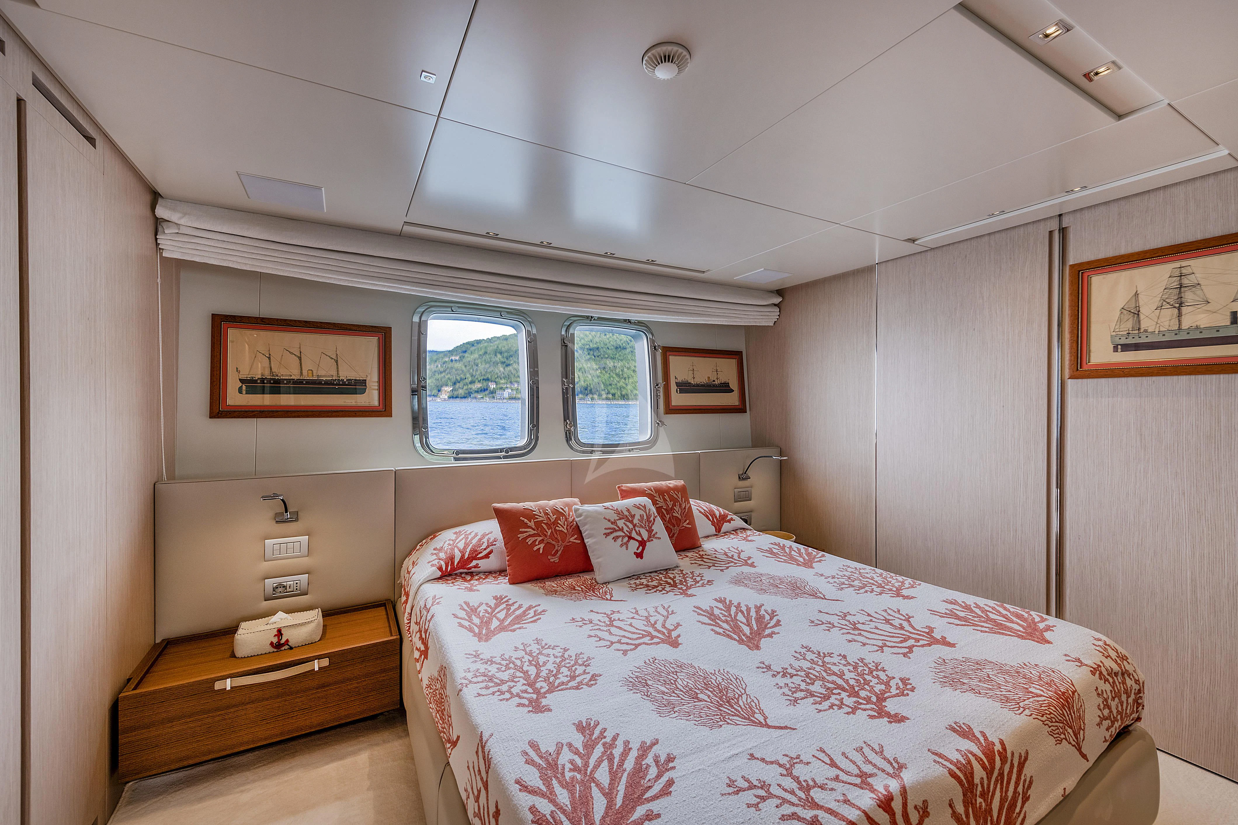 a bedroom with a bed and a dresser aboard VITTORIA Yacht for Charter