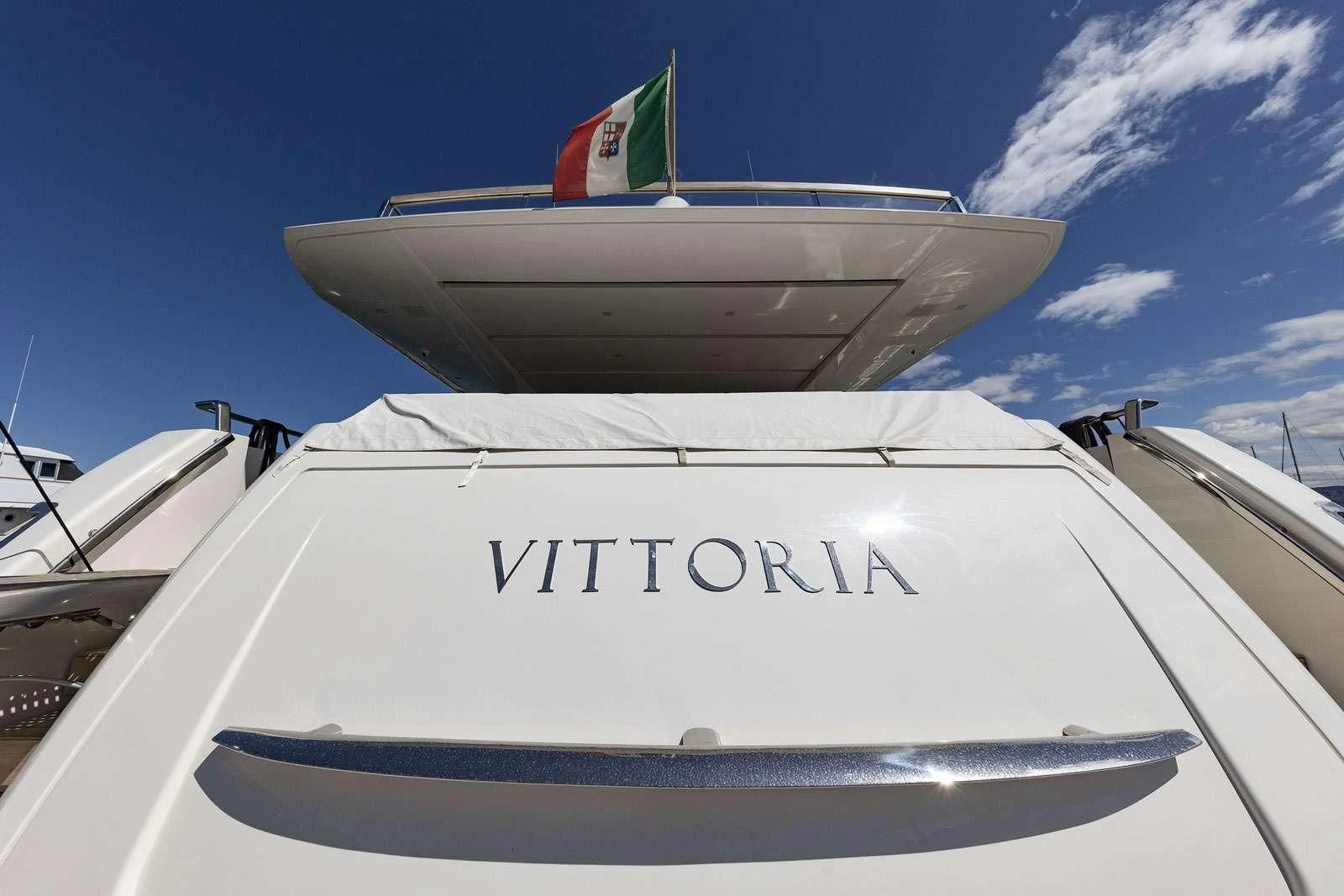 a white boat with a flag on it aboard VITTORIA Yacht for Charter