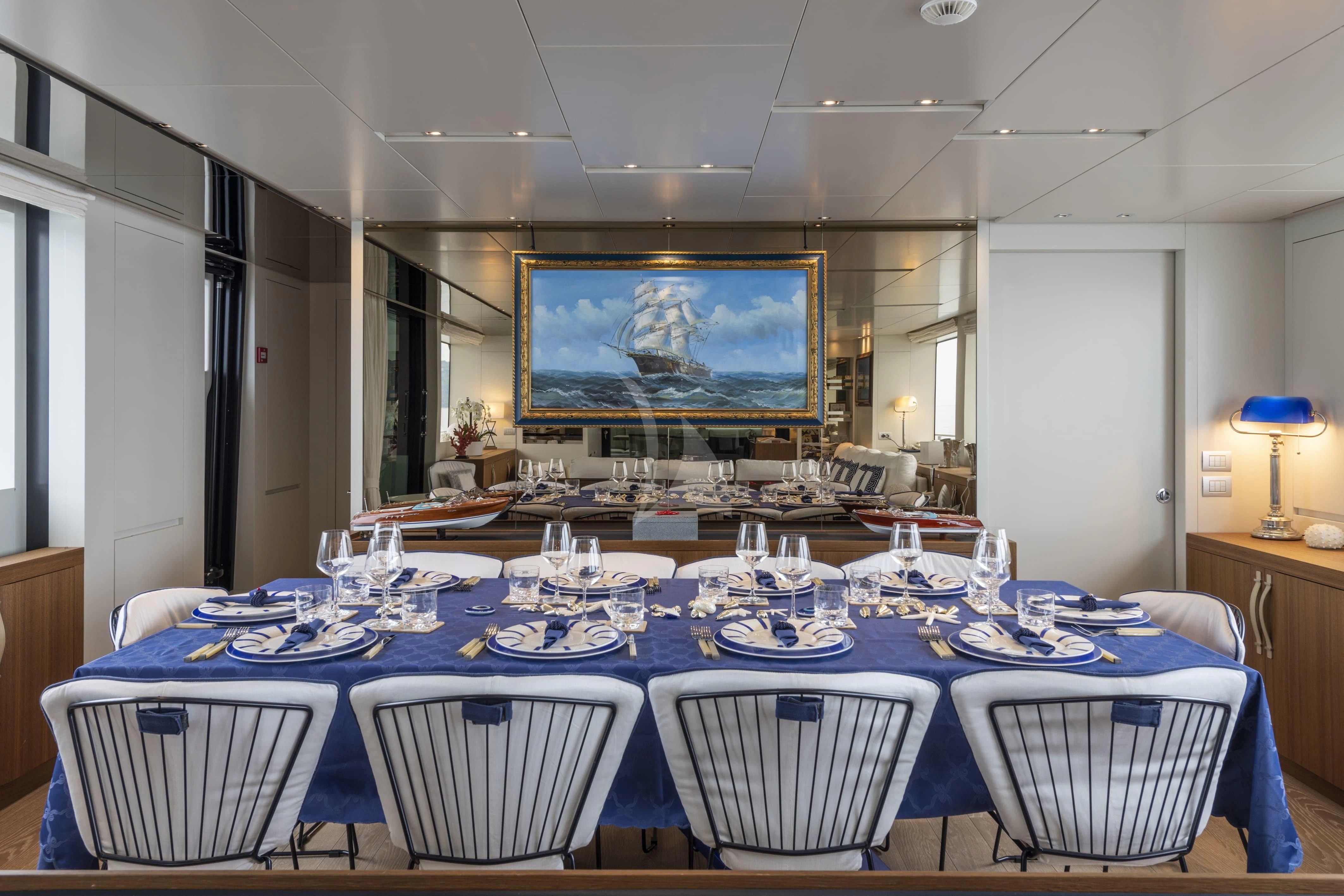 a large dining room with blue and white tables and chairs aboard VITTORIA Yacht for Charter