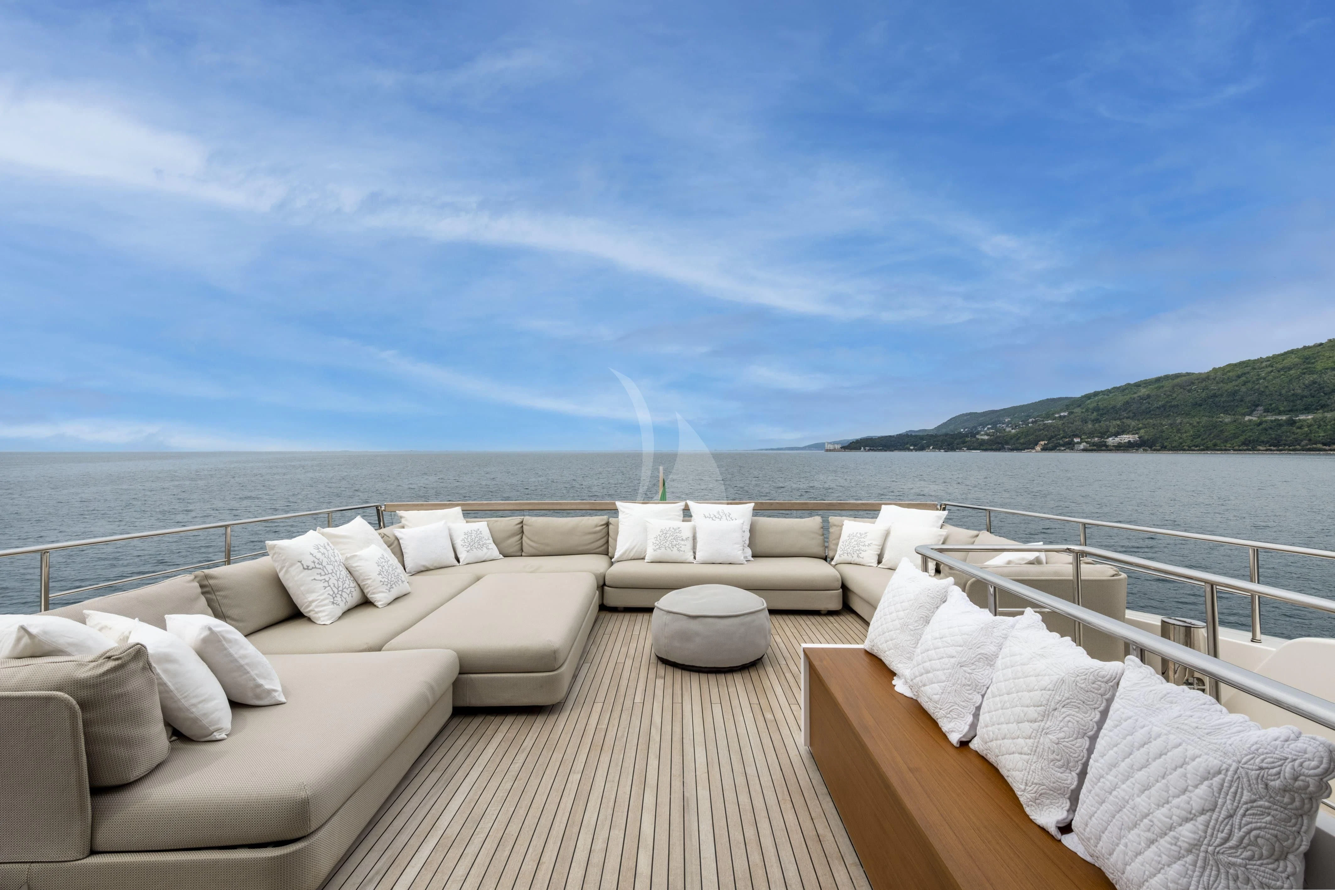 a deck with chairs and a body of water in the background aboard VITTORIA Yacht for Charter