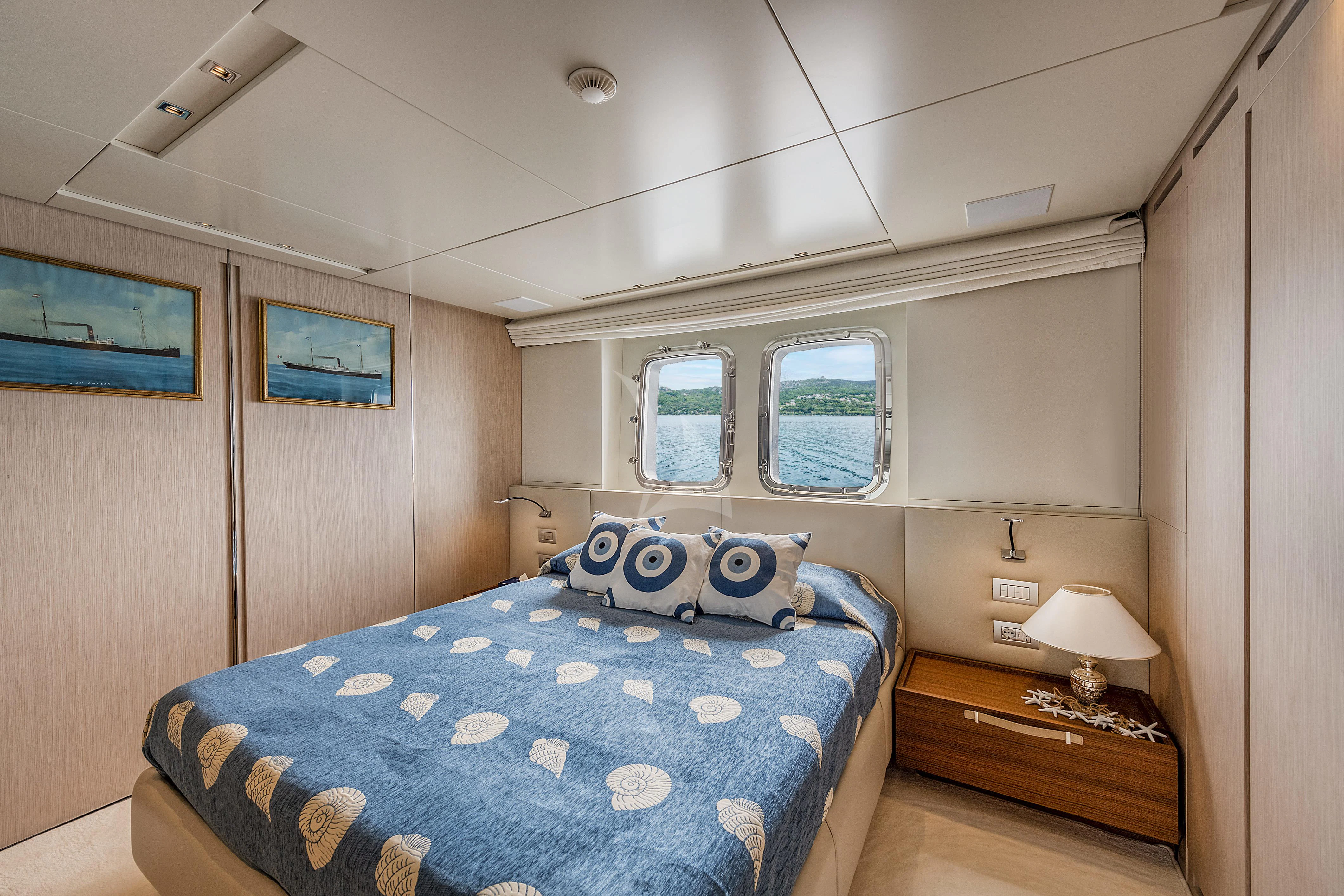 a bedroom with a blue bed spread aboard VITTORIA Yacht for Charter