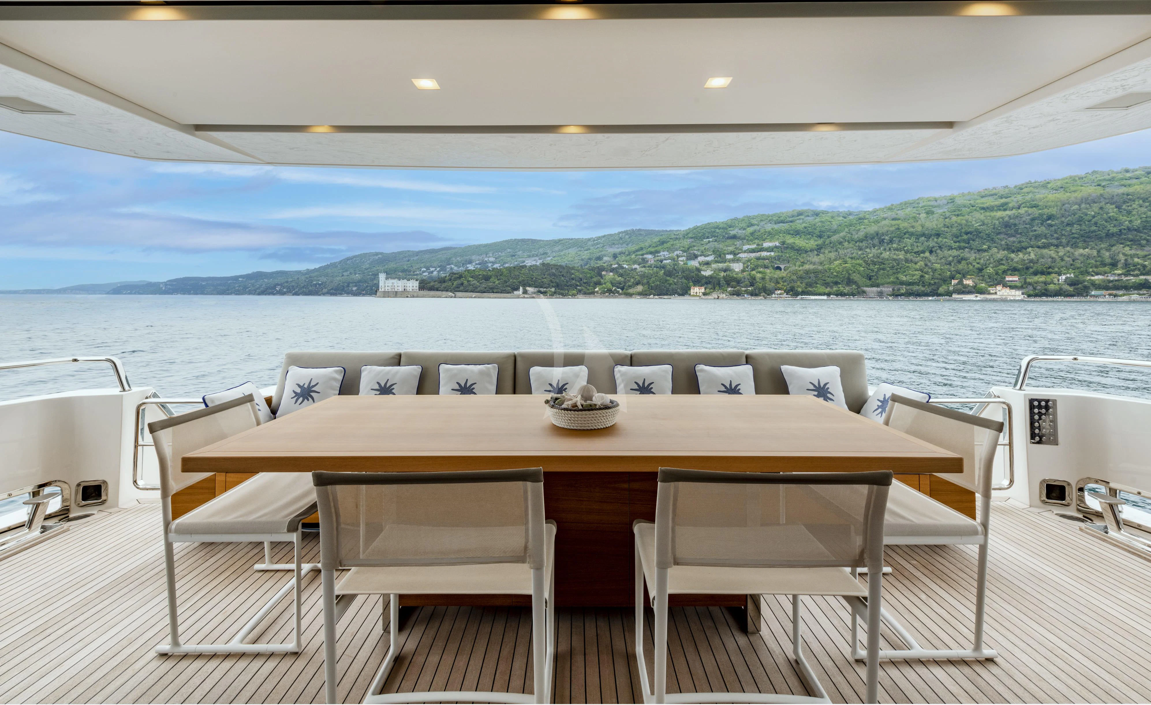 a table and chairs on a deck overlooking a body of water aboard VITTORIA Yacht for Charter