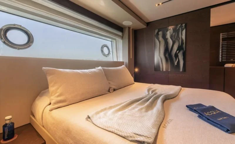 a bed with a white comforter aboard ACQUA Yacht for Sale