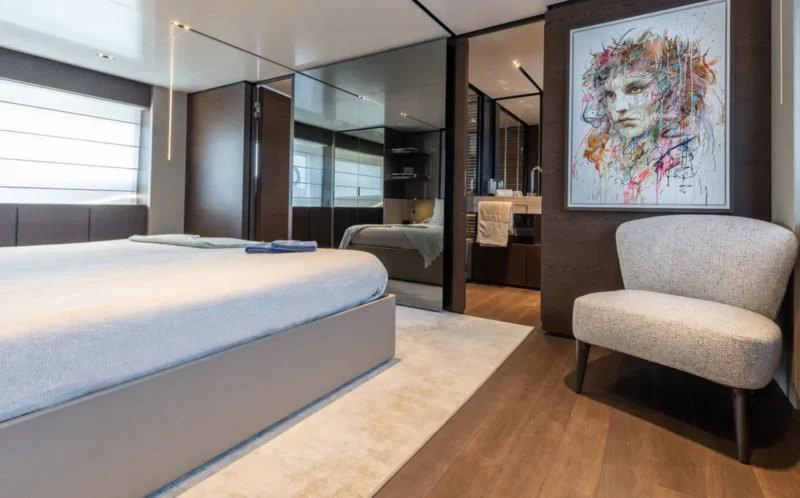 a bedroom with a bed and a chair aboard ACQUA Yacht for Sale