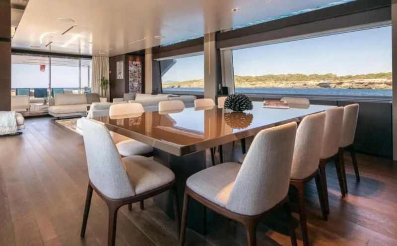 a large dining table with chairs aboard ACQUA Yacht for Sale