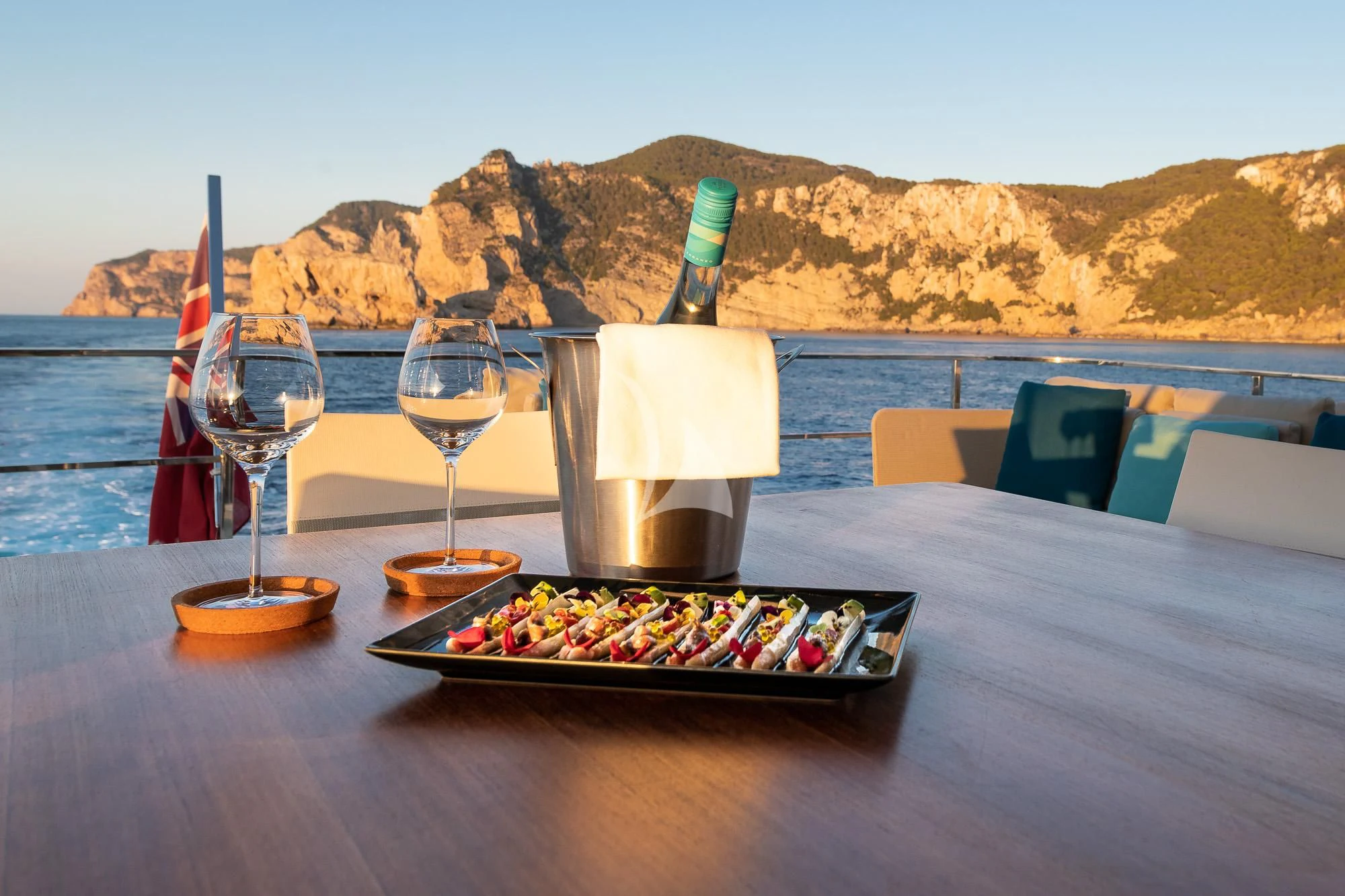 a bottle of wine and a glass of wine on a table aboard ACQUA Yacht for Sale