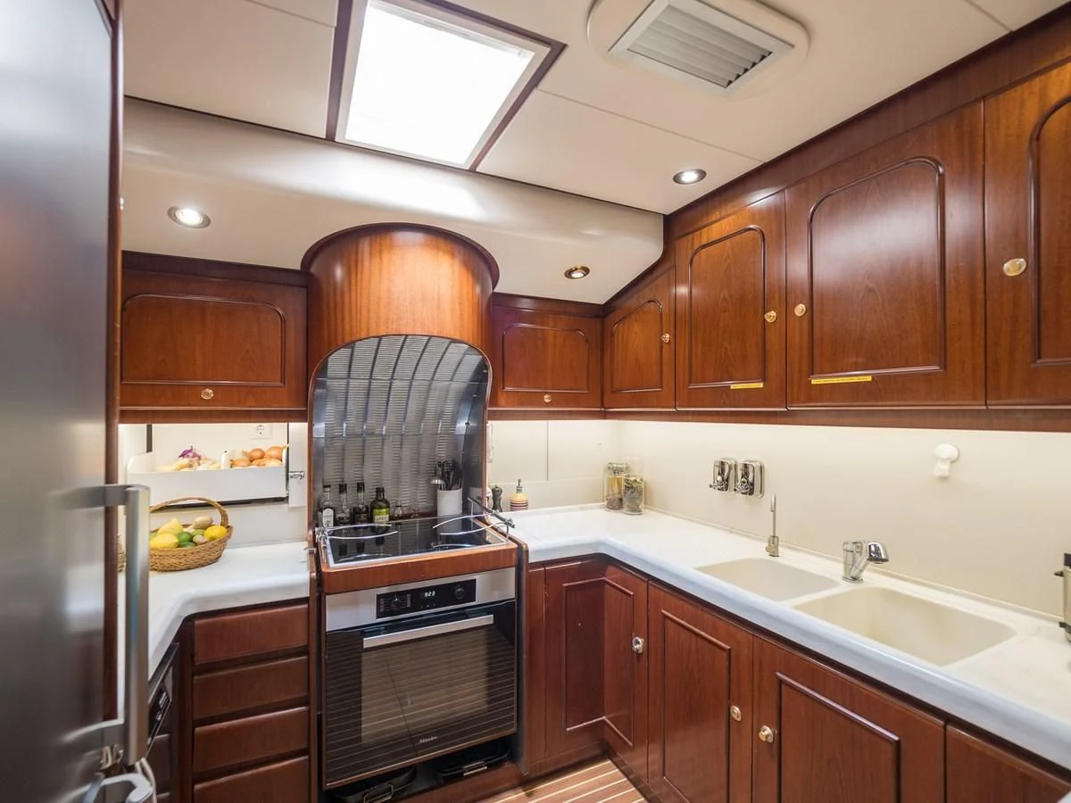 a kitchen with wooden cabinets aboard BLUE PAPILLON Yacht for Sale