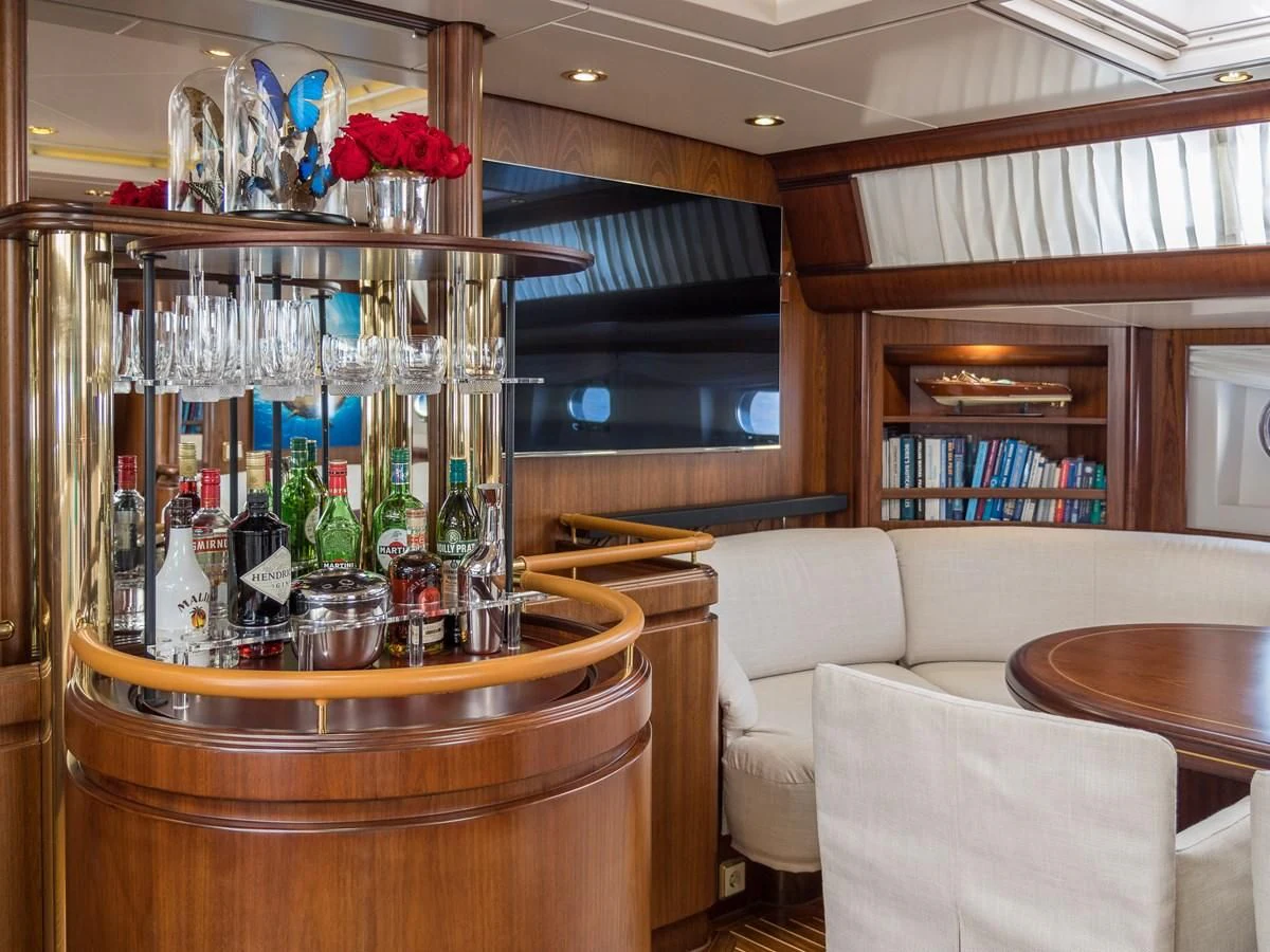a bar with a table and chairs aboard BLUE PAPILLON Yacht for Sale
