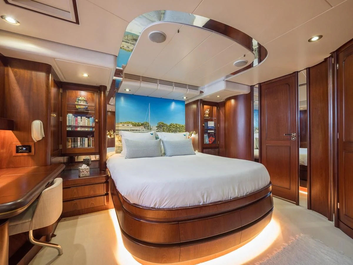 a room with a bed and a bookcase aboard BLUE PAPILLON Yacht for Sale