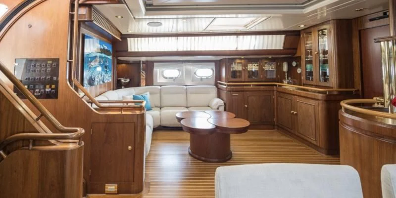 a living room with a table and couches aboard BLUE PAPILLON Yacht for Sale