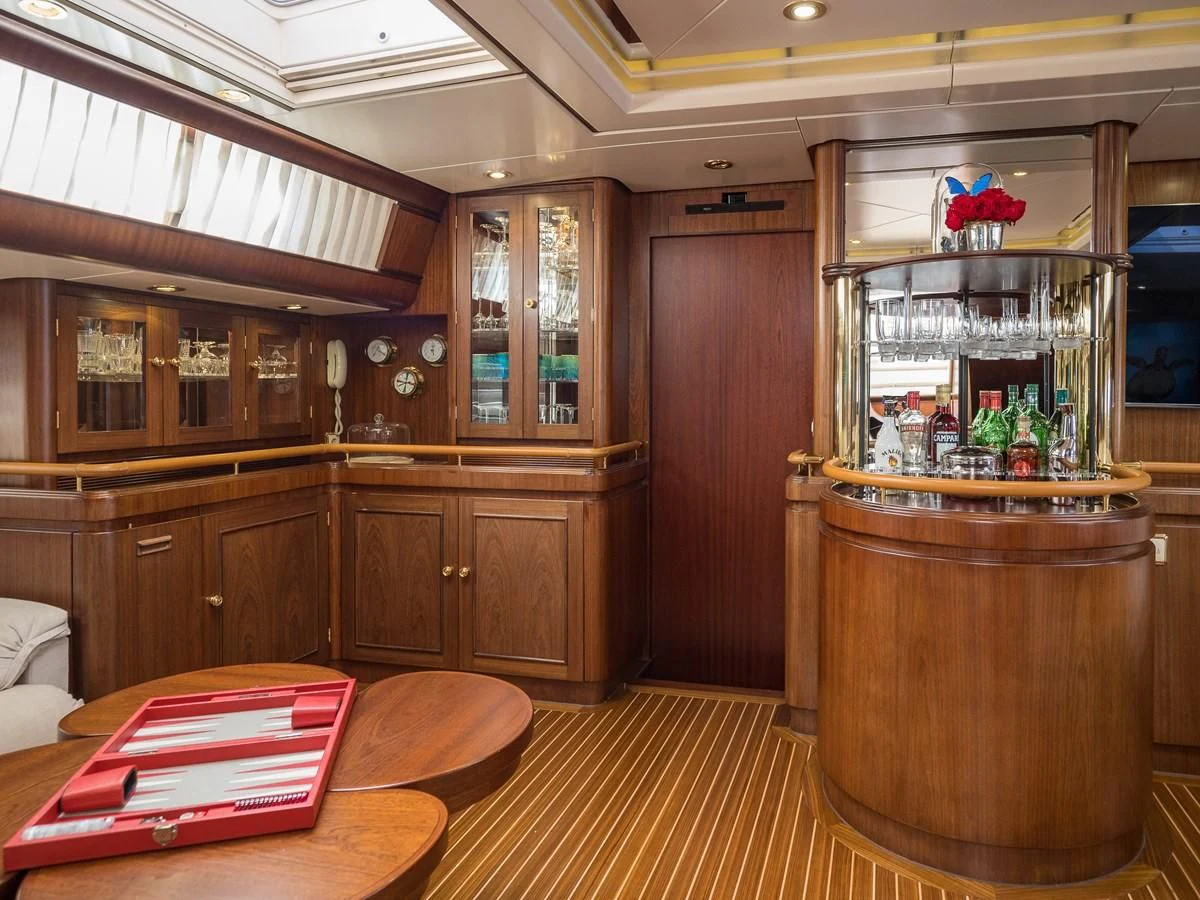 a room with wooden cabinets and a table and a large wood cabinet aboard BLUE PAPILLON Yacht for Sale
