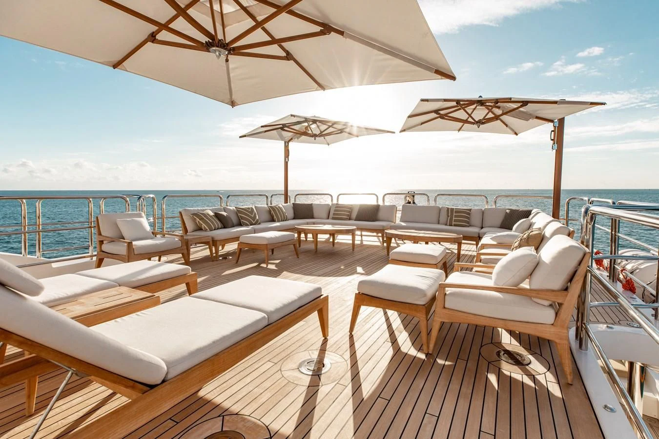a deck with lounge chairs and umbrellas on a sunny day aboard SORRENTO Yacht for Sale