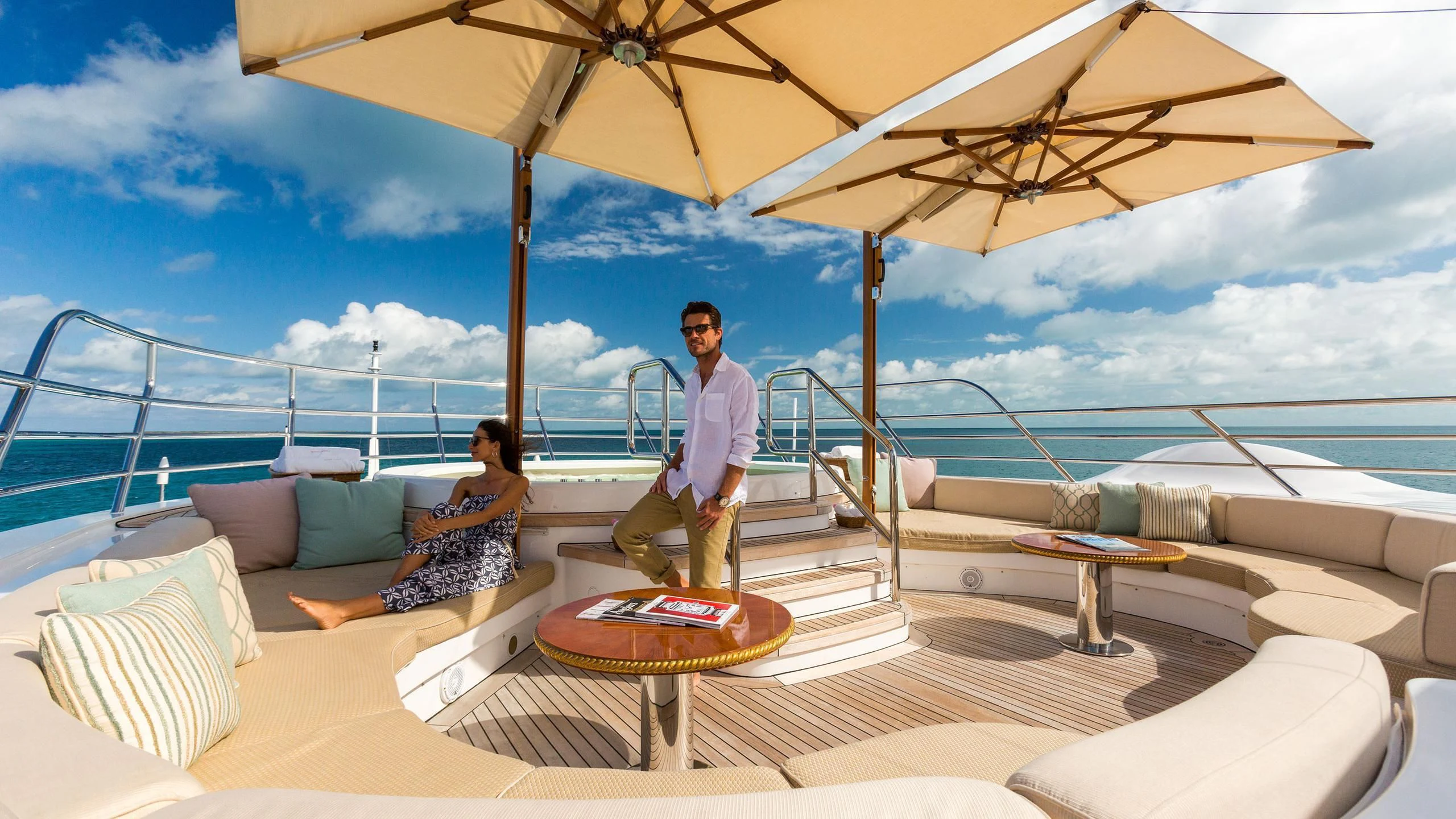 a man and woman sitting on a lounge chair under an umbrella aboard SORRENTO Yacht for Sale