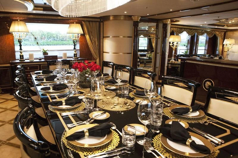 a large dining table with plates and glasses aboard SORRENTO Yacht for Sale