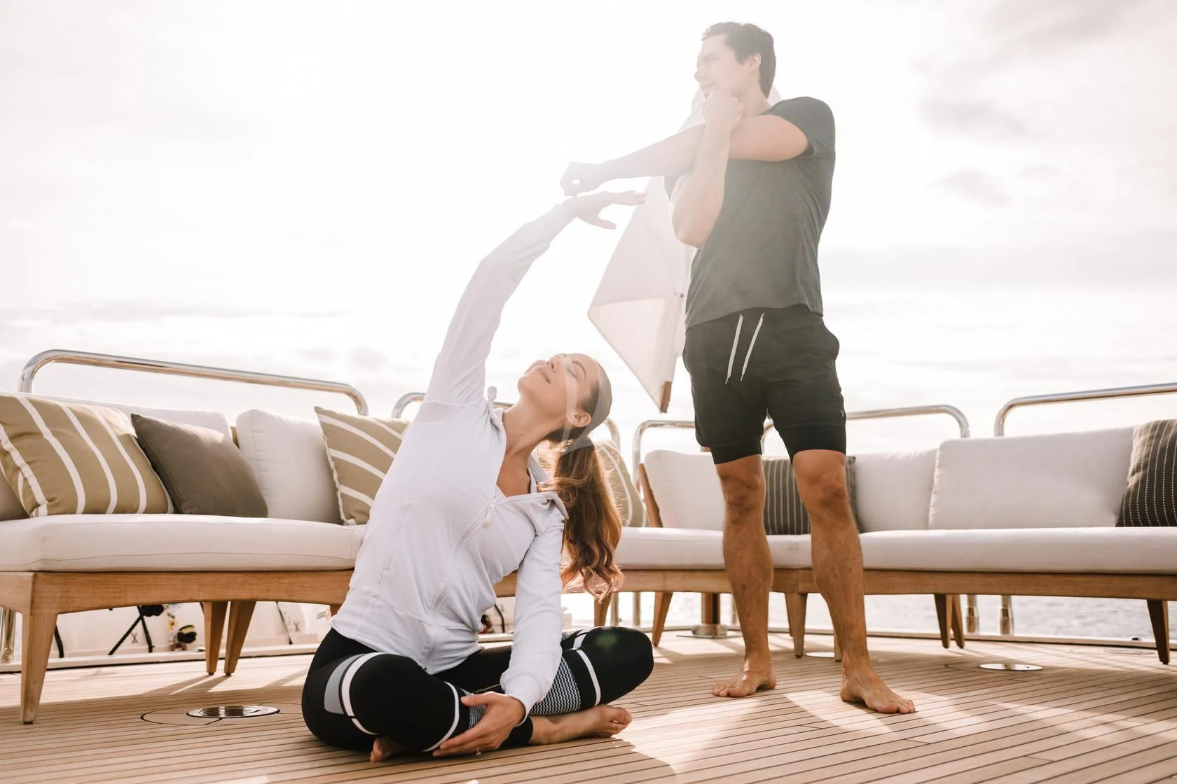 a woman doing a handstand with a man in the background aboard SORRENTO Yacht for Sale