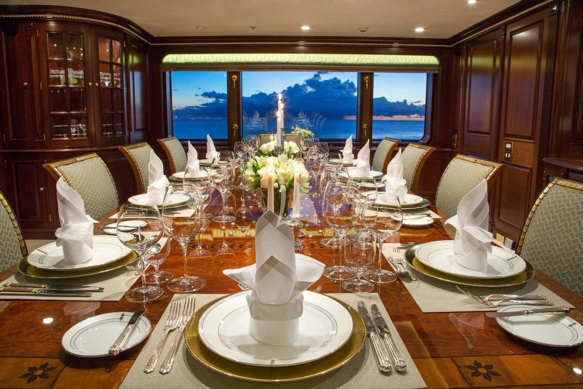 a table set with plates and glasses aboard TELEOST Yacht for Sale
