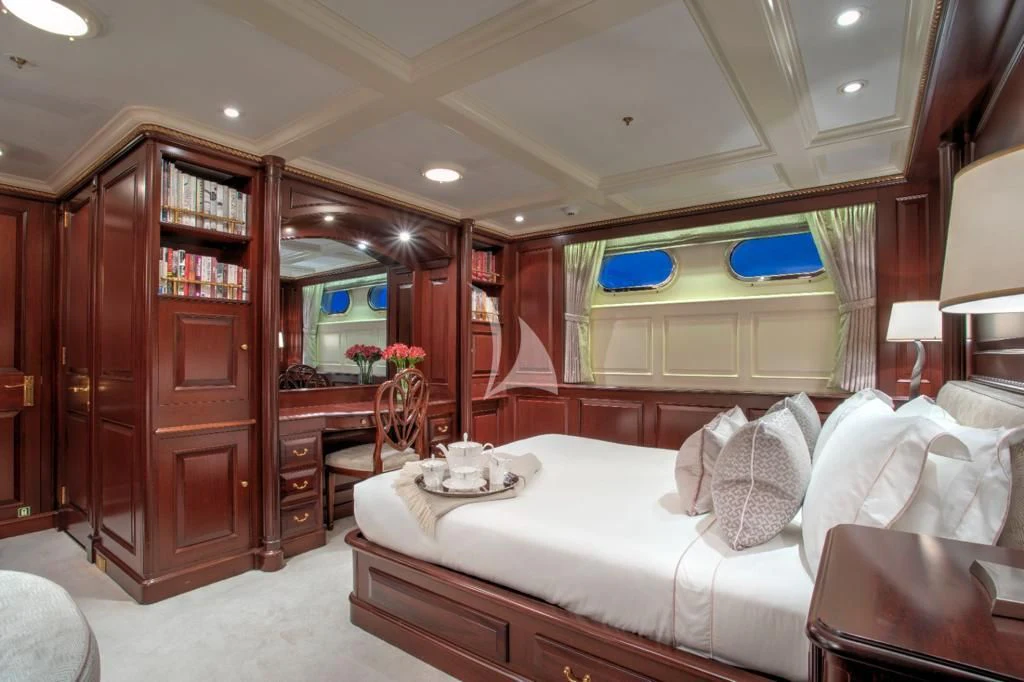 a bedroom with a bed and a desk aboard TELEOST Yacht for Sale