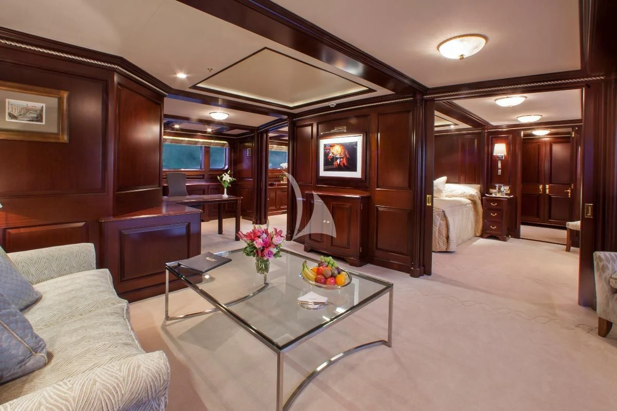 a living room with a table and couches aboard TELEOST Yacht for Sale