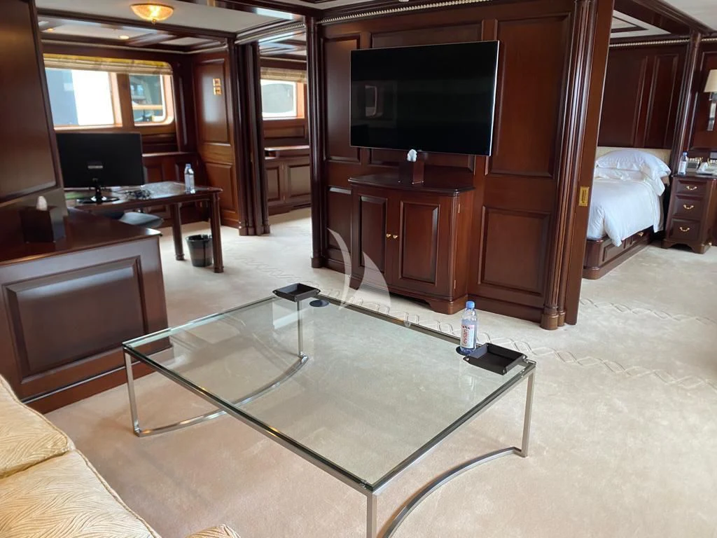 a living room with a table and tv aboard TELEOST Yacht for Sale