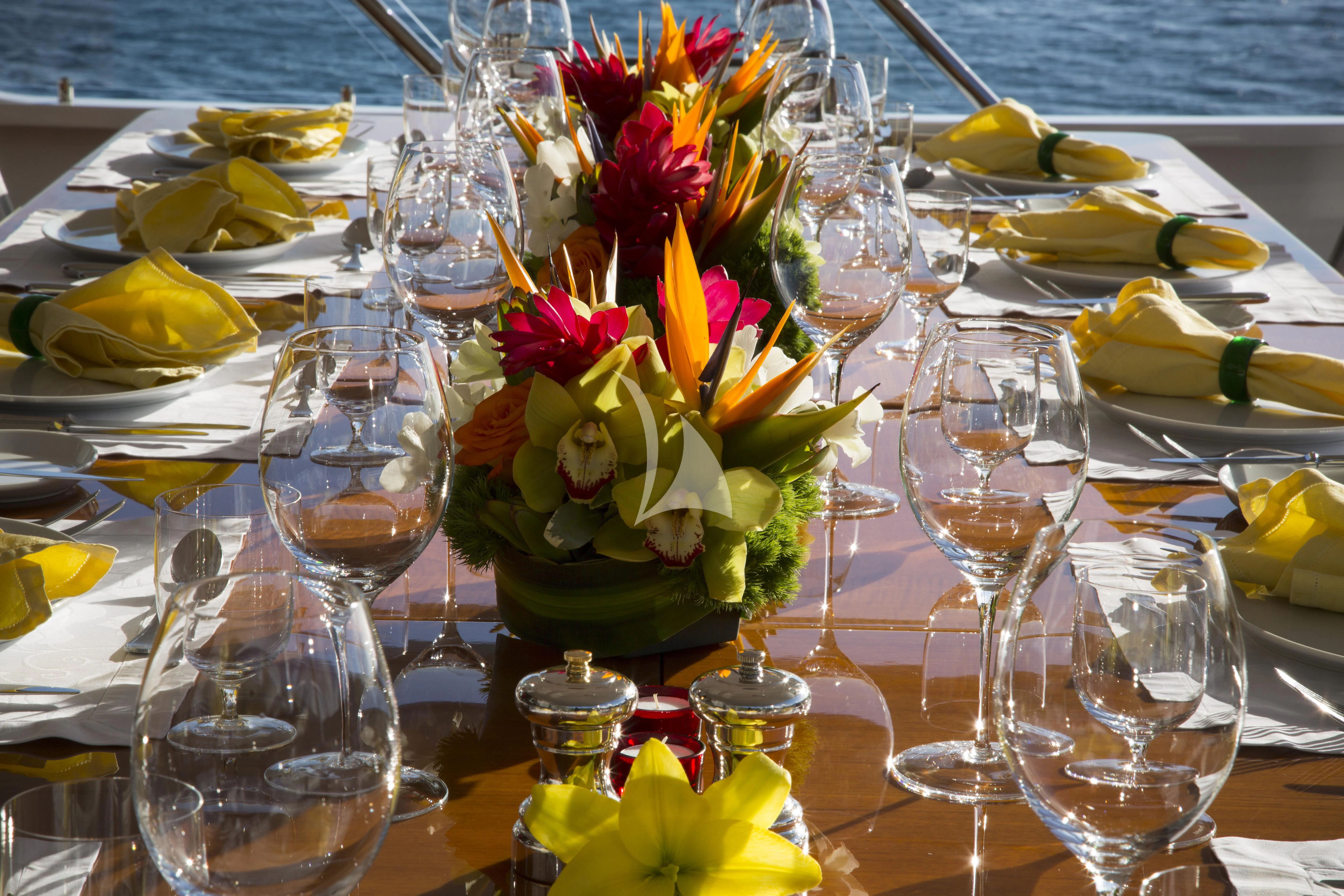 a table with wine glasses and flowers aboard TELEOST Yacht for Sale