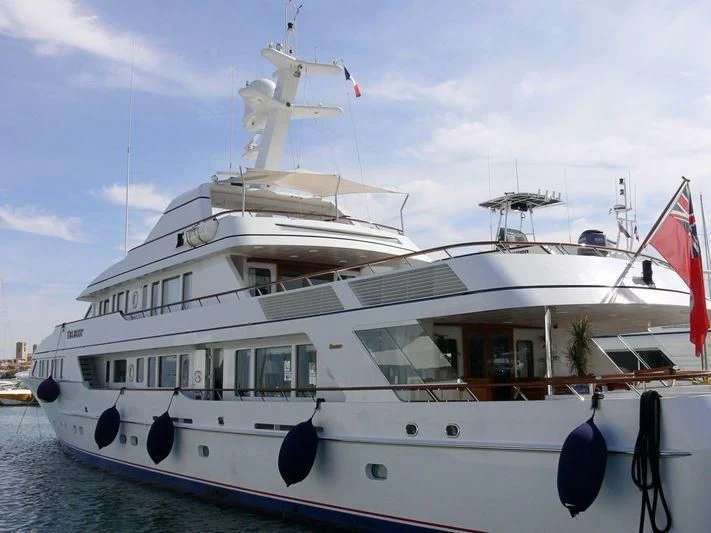 a large white boat with flags aboard TELEOST Yacht for Sale