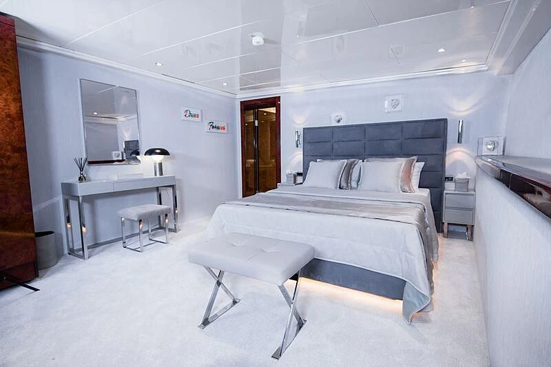 a bedroom with a bed and desk aboard HALLO Yacht for Sale