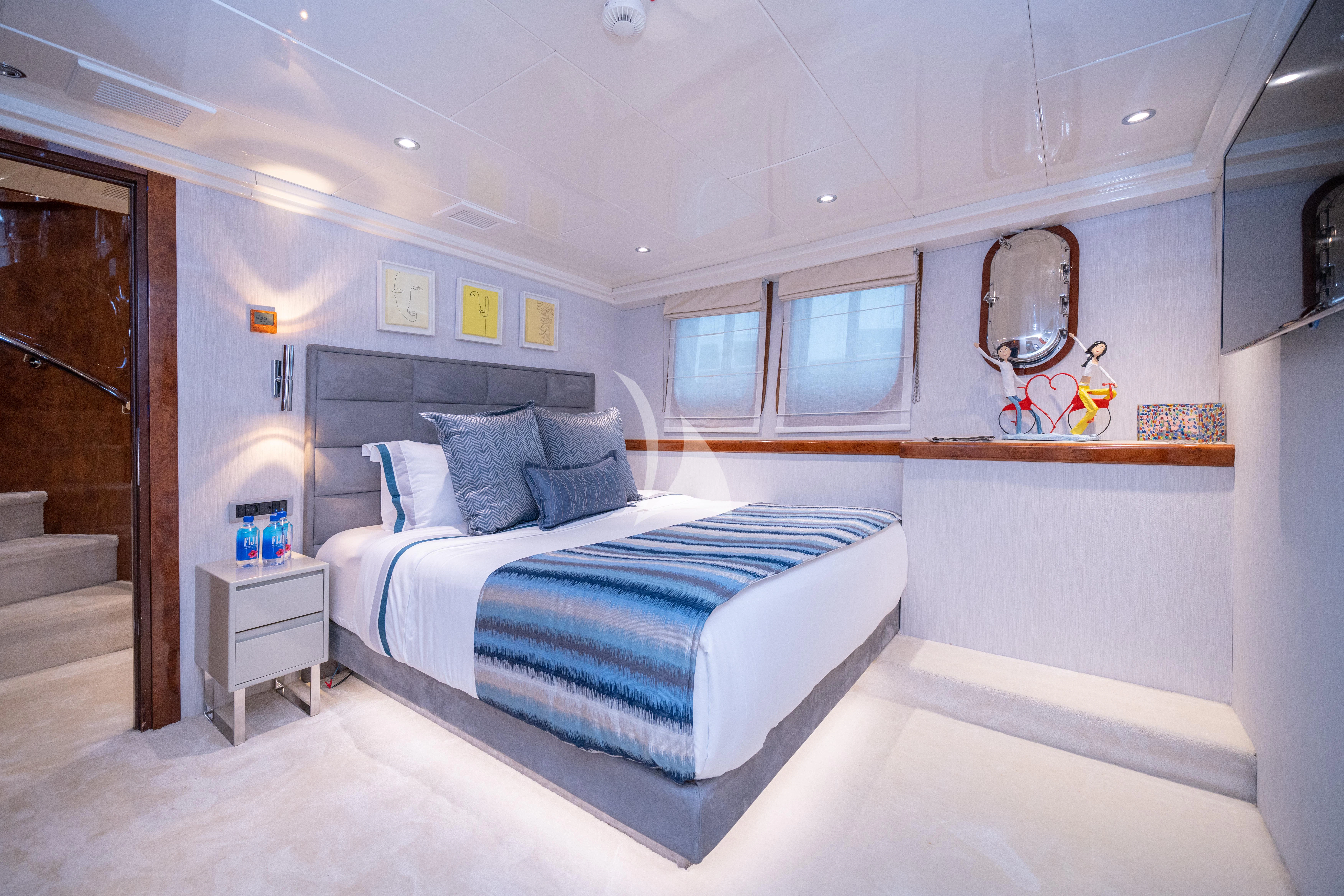 a bedroom with a bed and a mirror aboard HALLO Yacht for Sale