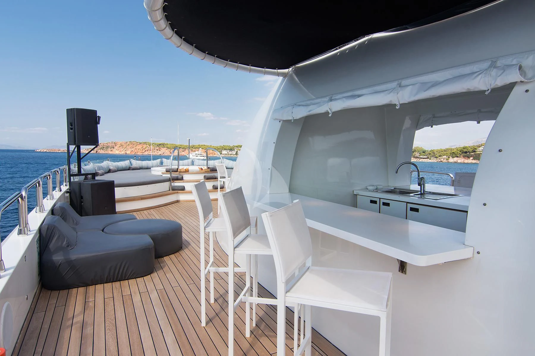 a deck with a view of the water and the land below aboard HALLO Yacht for Sale
